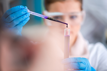 Image showing female student with protective glasses making chemistry experime