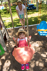 Image showing mother and daughter swinging in the park