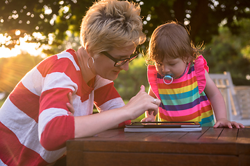 Image showing mom and her little daughter using tablet computer