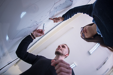 Image showing students writing on the white chalkboard