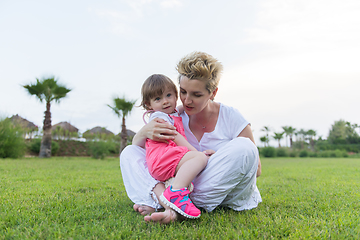 Image showing mother and little daughter playing at backyard