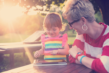 Image showing mom and her little daughter using tablet computer