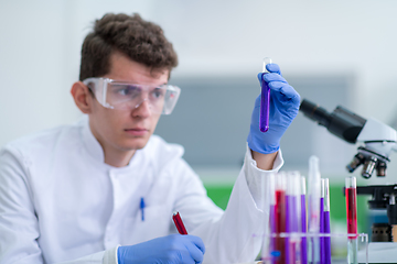 Image showing student with protective glasses making chemistry experiment