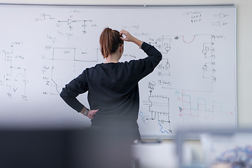 Image showing female student writing on board in classroom