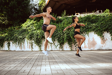 Image showing A muscular athletes doing workout on the city\'s street or park