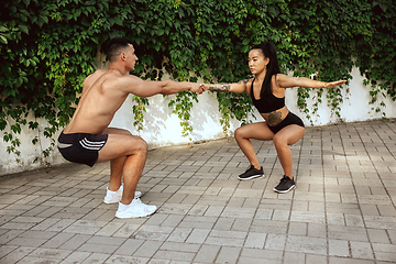 Image showing A muscular athletes doing workout on the city\'s street or park