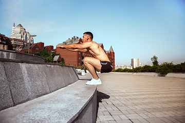 Image showing A male athlete doing workout on the city\'s street or park