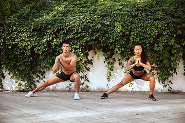 Image showing A muscular athletes doing workout on the city\'s street or park