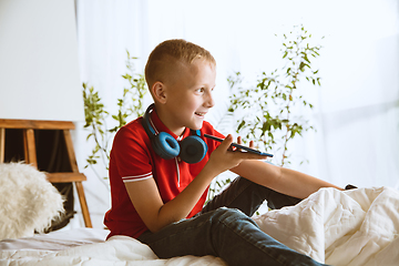 Image showing Little boy using different gadgets at home