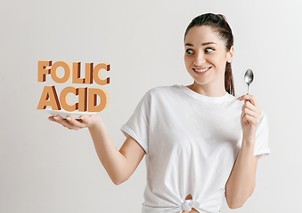 Image showing Food concept. Model holding a plate with letters of Folic Acid
