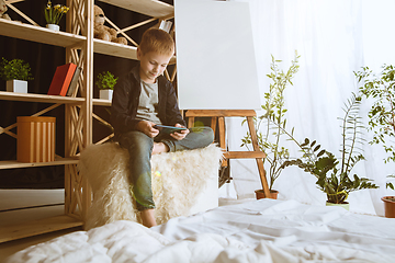 Image showing Little boy using different gadgets at home