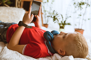 Image showing Little boy using different gadgets at home