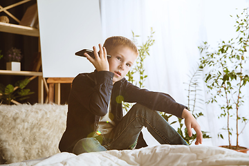 Image showing Little boy using different gadgets at home