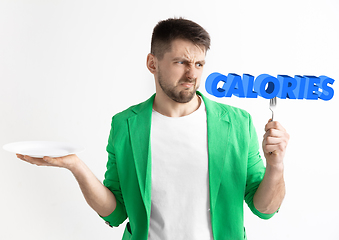 Image showing Food concept. Model holding a plate with letters of Calories