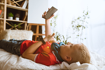 Image showing Little boy using different gadgets at home