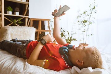 Image showing Little boy using different gadgets at home