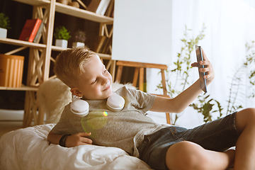 Image showing Little boy using different gadgets at home