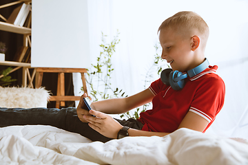 Image showing Little boy using different gadgets at home