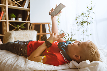 Image showing Little boy using different gadgets at home