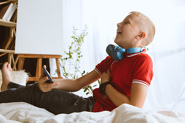 Image showing Little boy using different gadgets at home