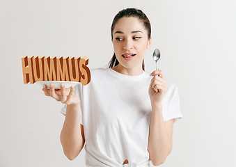 Image showing Food concept. Model holding a plate with letters of Hummus