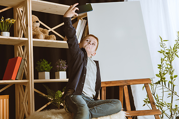 Image showing Little boy using different gadgets at home