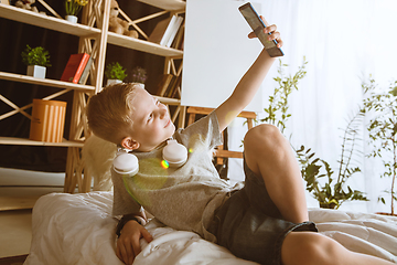 Image showing Little boy using different gadgets at home