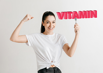 Image showing Food concept. Model holding a plate with letters of Vitamin