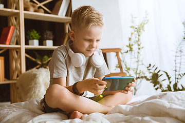 Image showing Little boy using different gadgets at home