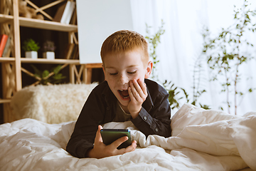 Image showing Little boy using different gadgets at home