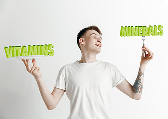 Image showing Food concept. Model holding a plate with letters of Vitamins, Minerals