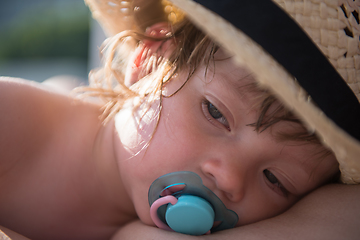 Image showing mother and tired little daughter resting on sunbed