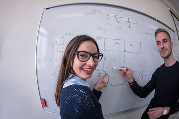 Image showing students writing on the white chalkboard