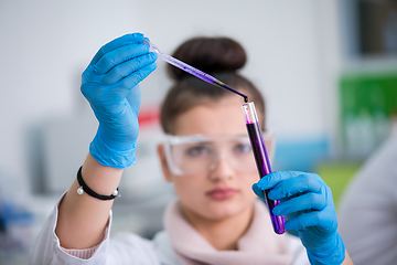 Image showing female student with protective glasses making chemistry experime