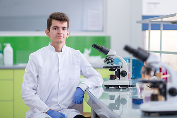 Image showing student scientist looking through a microscope