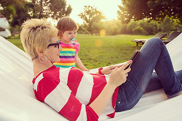 Image showing mom and a little daughter relaxing in a hammock