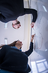 Image showing students writing on the white chalkboard