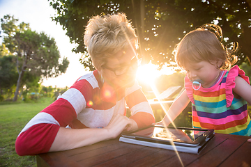 Image showing mom and her little daughter using tablet computer