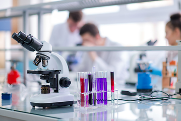 Image showing Microscope on the workplace near test tubes