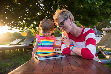 Image showing mom and her little daughter using tablet computer