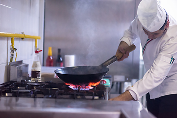 Image showing chef preparing food, frying in wok pan