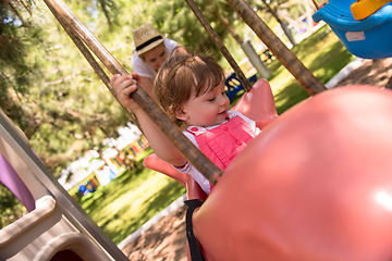 Image showing mother and daughter swinging in the park