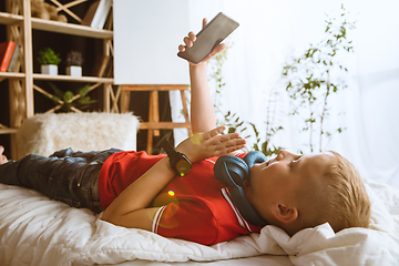 Image showing Little boy using different gadgets at home