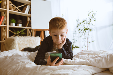 Image showing Little boy using different gadgets at home