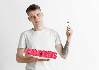 Image showing Food concept. Model holding a plate with letters of Calories