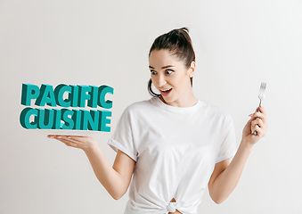 Image showing Food concept. Model holding a plate with letters of Pacific Cuisine