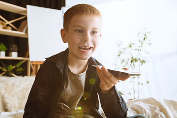 Image showing Little boy using different gadgets at home