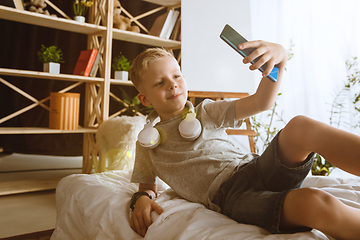 Image showing Little boy using different gadgets at home