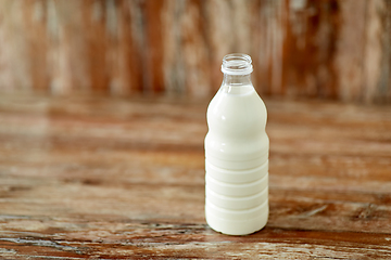 Image showing bottle of milk on wooden table