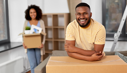 Image showing happy couple with boxes moving to new home